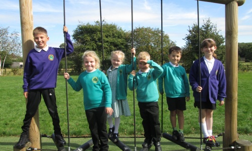 smiling children on playground equipment.